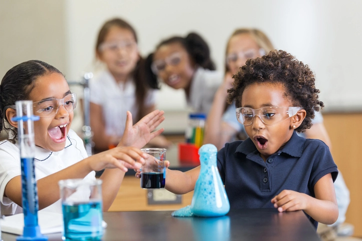 Kids having fun with science experiments. Blue foam coming out of a jar