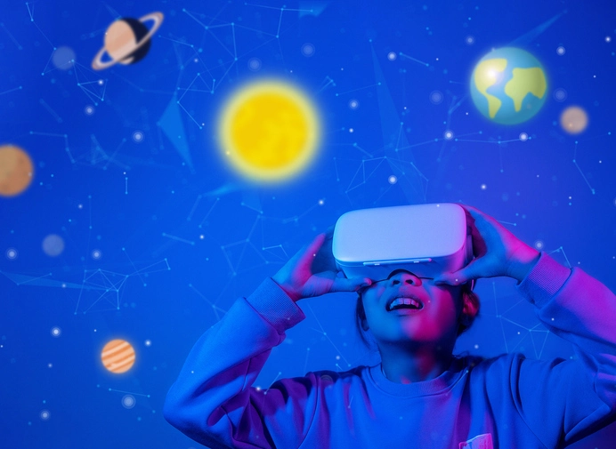 Kid looking in VR glasses with drawings of planets and stars around in a blue room