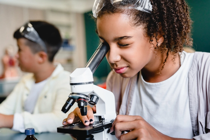 Girl looking in a microscope in a science class