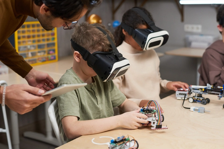 Kids with VR glasses on learning and building stuff